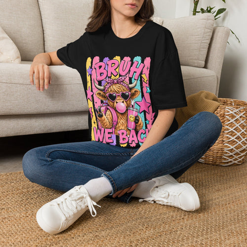 Black graphic t-shirt on model sitting, featuring “BRUH WE BACK” cow-themed star art