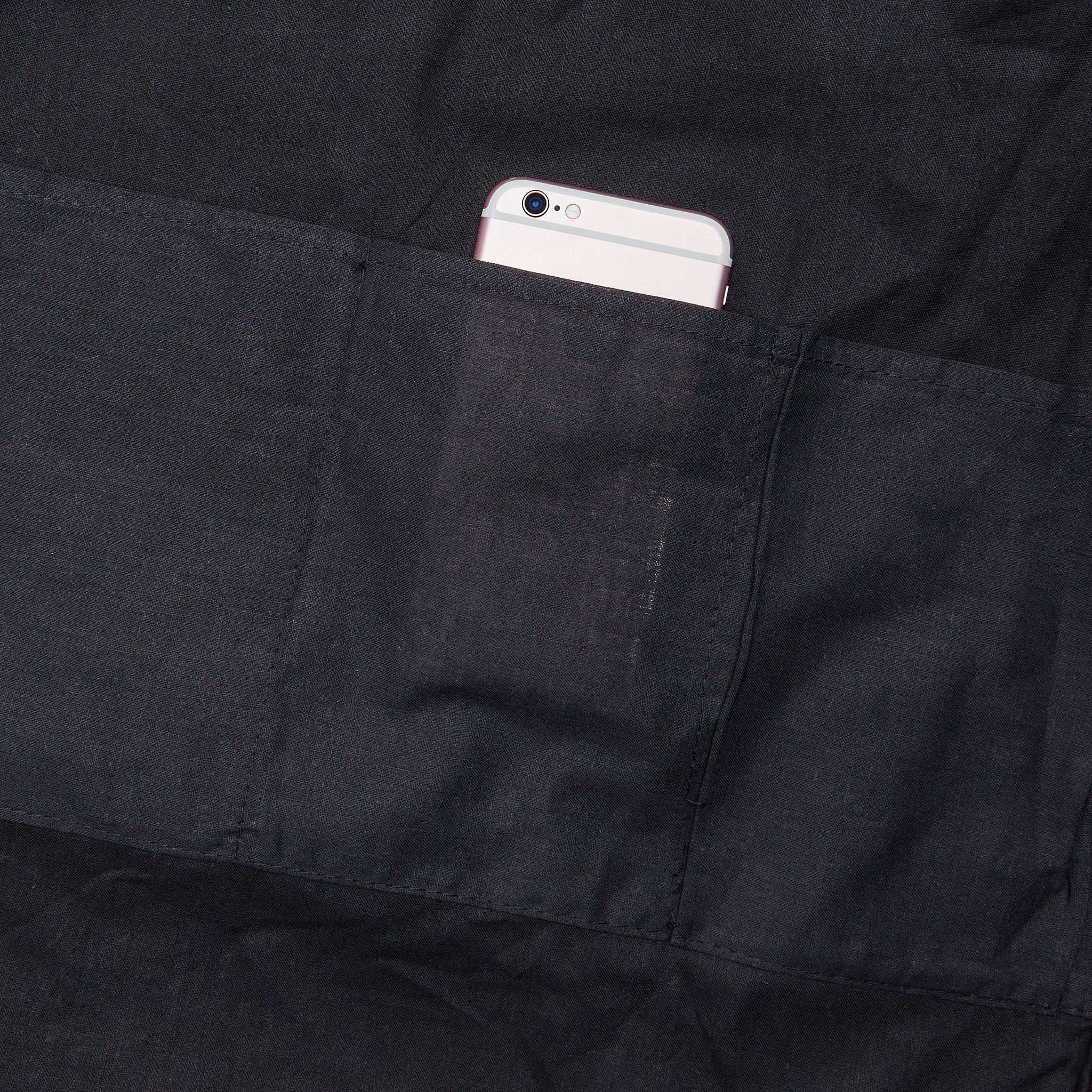 Dark interior pocket holding a smartphone inside the tote bag.